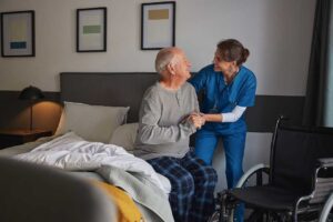 A senior resident arranging family photos and a favorite blanket in a personalized assisted living room.